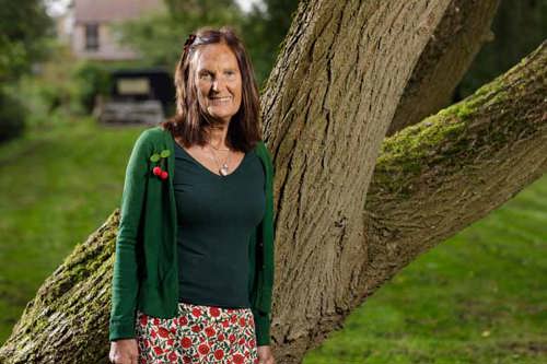 Louise, who has had an hip replacement, stood outside next to a tree.