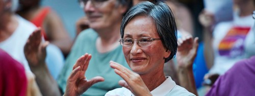 A lady doing exercises with a community group.