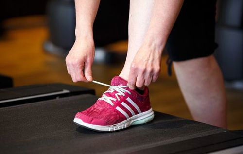 Woman tying shoelace of red trainer