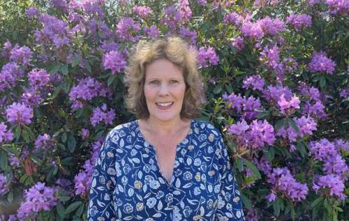 Researcher Gretl standing in front of some flowers