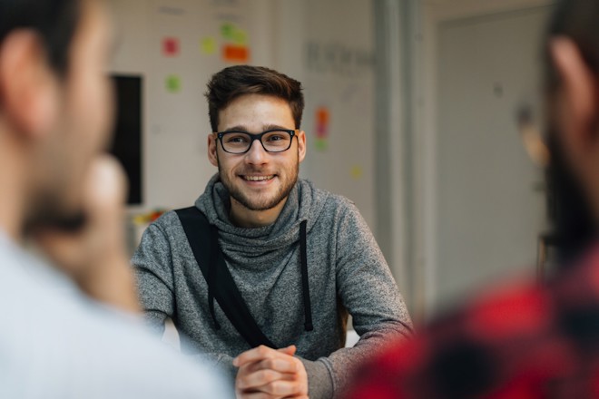 Man sat at desk smiling