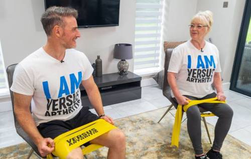 Leon and his mum sitting down smiling with resistance band around legs