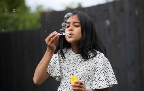 Sfiyah blowing bubbles in garden