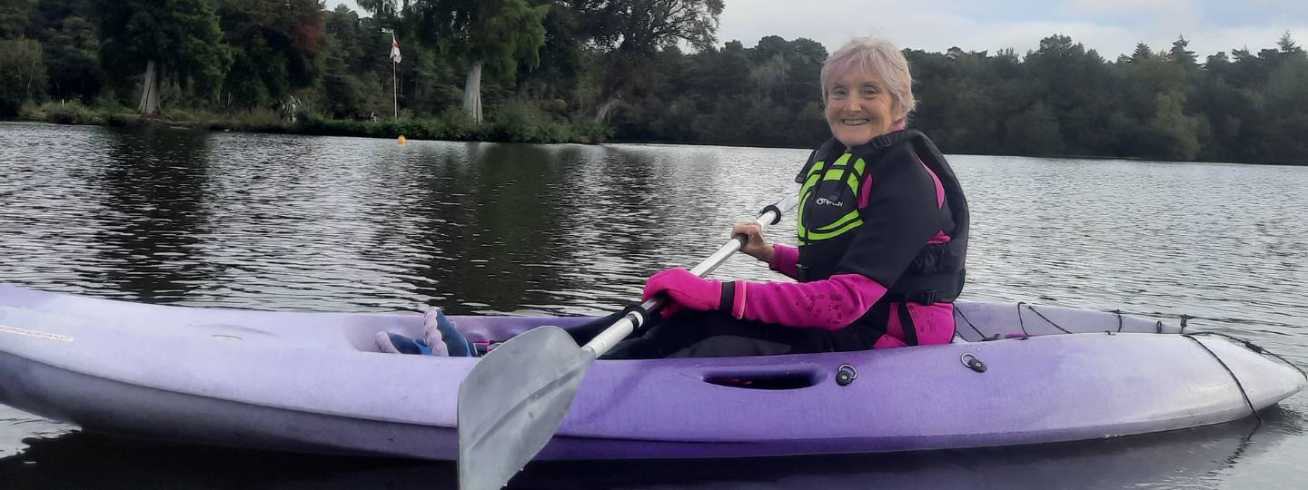 Smiling Josephine in a purple kayak on a river